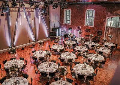 Festlich gedeckte Eventlocation mit Rundtischen und Blumendekoration für Events in Hannover